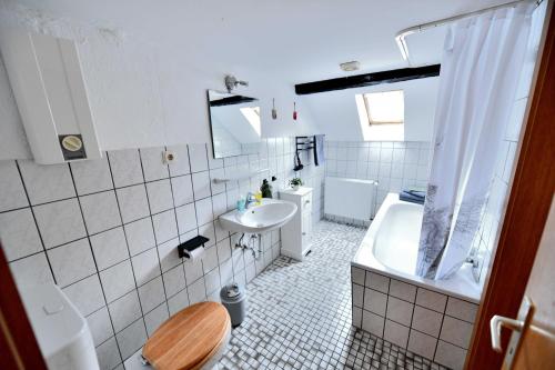 a bathroom with a toilet and a sink and a tub at Ferienwohnung im alten Bauernhaus in Lindlar
