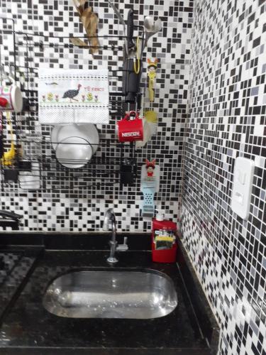 y baño con lavabo y azulejos blancos y negros. en Apartamento Temporada Dalva Copacabana 2, en Río de Janeiro