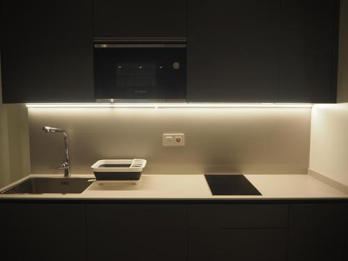 a kitchen counter with a sink and a microwave at Alojamientos Acella in Pamplona