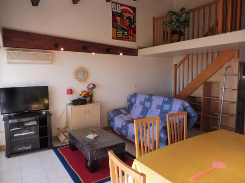 un salon avec un canapé et une table dans l'établissement MAISONS SUR LA PLAGE Magnifique T3 mezzanine vue mer Cap d'Agde, au Cap d'Agde