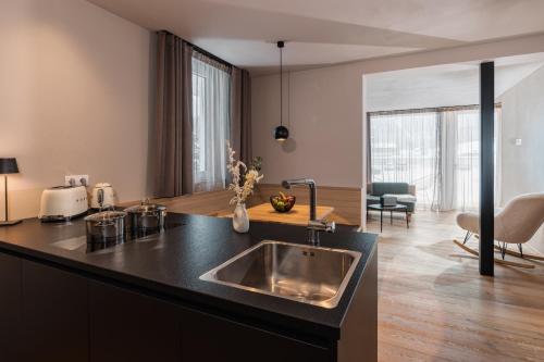 a kitchen with a sink and a living room at Ariane's Guesthouse in Sesto