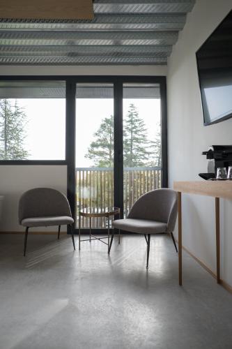 two chairs and a table in a room with windows at BOX ART ALPINO in Navacerrada