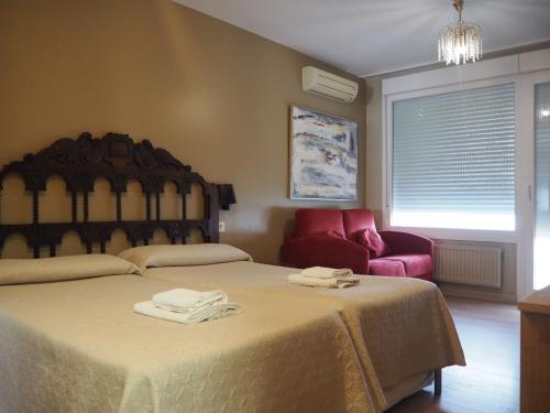 a bedroom with a large bed with two towels on it at Alojamientos Acella in Pamplona