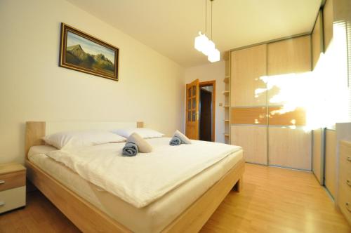 ein Schlafzimmer mit einem großen weißen Bett in einem Zimmer in der Unterkunft Rodinný dom "Ako doma" in Veľký Slavkov