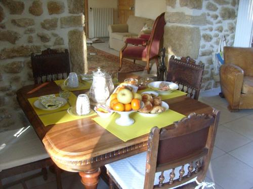 una mesa de madera con un bol de fruta. en La Maison Ocre en Rochegude