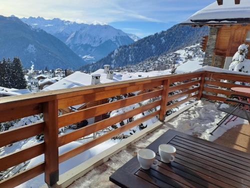uma varanda com uma mesa e vista para as montanhas em Apartment Porthos 37 by Interhome em Verbier