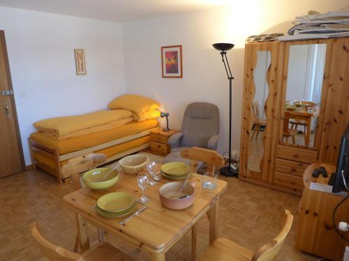 ein Wohnzimmer mit einem Tisch und einem Bett in der Unterkunft Apartment Cransalpin-4 by Interhome in Vermala