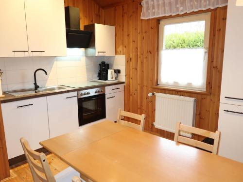 een keuken met witte kasten en een houten tafel bij Chalet Martin by Interhome in Otterndorf