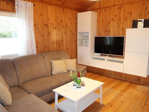 een woonkamer met een bank en een tv bij Chalet Martin by Interhome in Otterndorf