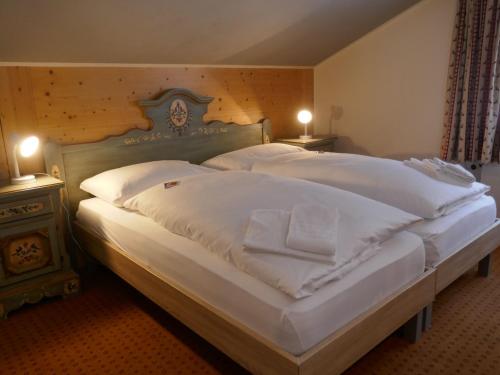ein Schlafzimmer mit einem großen Bett mit weißer Bettwäsche und Kissen in der Unterkunft Apartment Chalet Schwendihus-11 by Interhome in Grindelwald