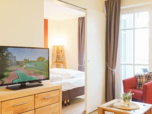 a hotel room with a television and a bed at Apartment Seepark Sellin-2 by Interhome in Ostseebad Sellin