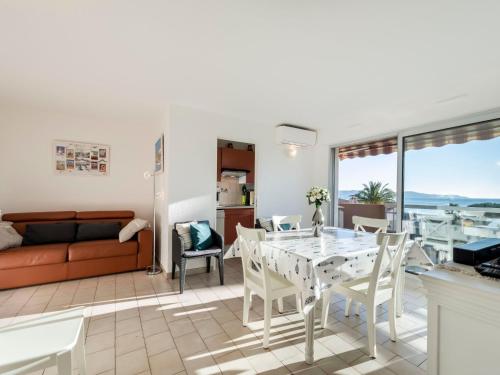 un salon avec une table, des chaises et un canapé dans l'établissement Apartment Les Jardins del Mar-2 by Interhome, à Cavalaire-sur-Mer