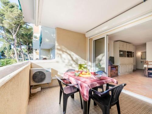 uma sala de jantar com mesa e cadeiras e uma grande janela em Apartment Porto di Mar-6 by Interhome em Cavalaire-sur-Mer