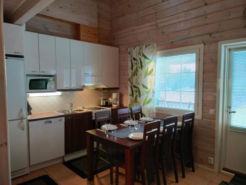 eine Küche mit Tisch und Stühlen in einem Zimmer in der Unterkunft Holiday Home Hovitahko a 1 by Interhome in Tahkovuori