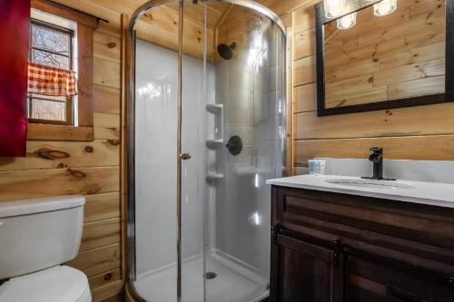 a bathroom with a shower and a toilet and a sink at Sweet Pea Tiny Home in Bryson City