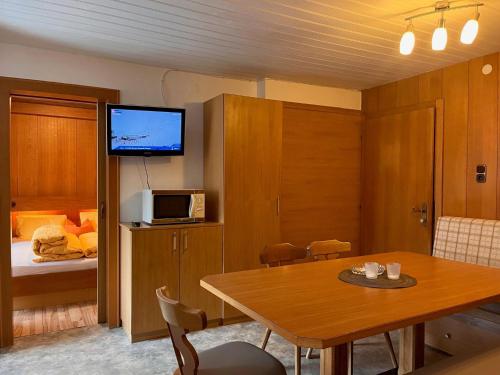 Zimmer mit einem Tisch und einem TV sowie einem Schlafzimmer. in der Unterkunft Apartment Scheiber - SOE131 by Interhome in Sölden