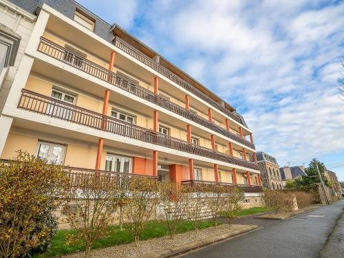an apartment building with orange balconies on a street at Apartment Cardella by Interhome in Saint Malo