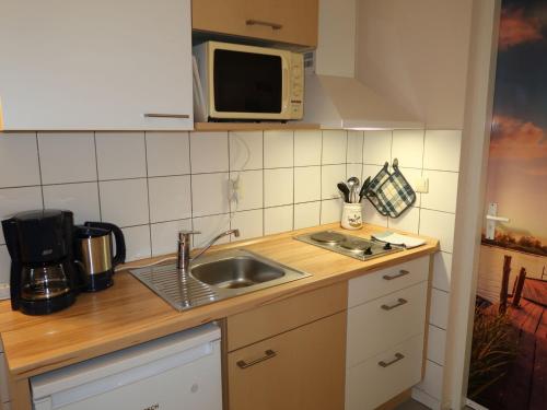 a kitchen with a sink and a microwave at Apartment Tossens-8 by Interhome in Butjadingen OT Tossens