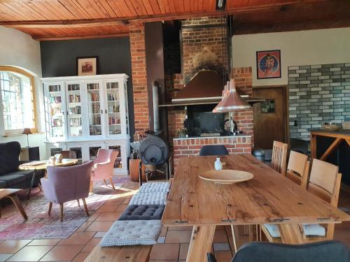 une salle à manger avec une table en bois et une cheminée dans l'établissement schmiede1860, à Groß Dratow