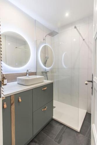 une salle de bain avec un lavabo et une douche avec un miroir dans l'établissement T3 rénové 10min gare Part dieu - Quartier typique, à Lyon