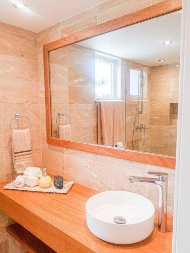 a bathroom with a sink and a mirror at Playa Dorada Suites in San Felipe de Puerto Plata