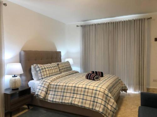 a bedroom with a bed with a checkered blanket at Playa Dorada Suites in San Felipe de Puerto Plata