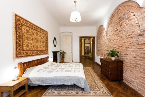 een slaapkamer met een bed en een bakstenen muur bij Apartamenty Gołębia 3 in Krakau