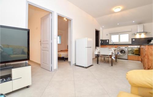 Il dispose d'une cuisine et d'un salon avec une télévision et une salle à manger. dans l'établissement Lovely Apartment In Ghisonaccia, à Ghisonaccia