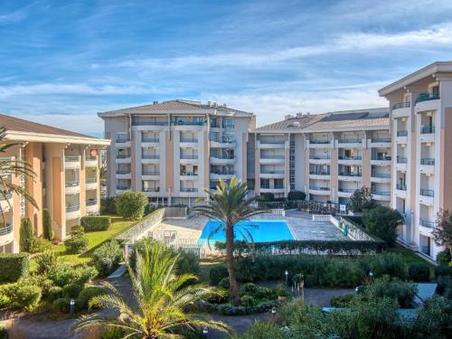 un complexe d'appartements avec piscine et palmiers dans l'établissement Apartment Le Cesarée-2 by Interhome, à Fréjus