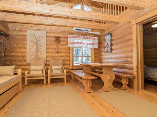 a log cabin living room with a table and chairs at Holiday Home Ruka-kitkan lomamajat-tilhi by Interhome in Säkkilänvaara