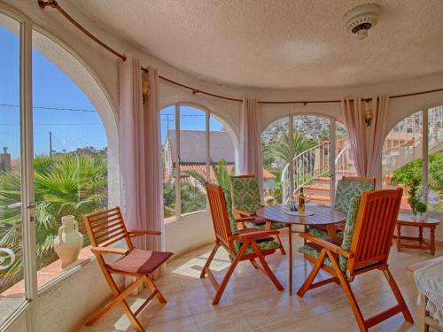 porche con mesa, sillas y ventanas en Villa Estrella by Interhome, en Calpe