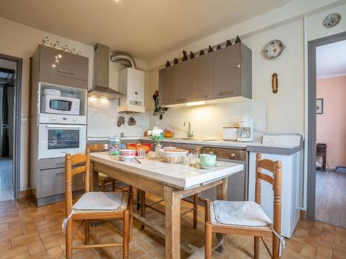 Il comprend une cuisine avec une table et des chaises en bois. dans l'établissement Holiday Home Saint Ideuc by Interhome, à Saint-Malo