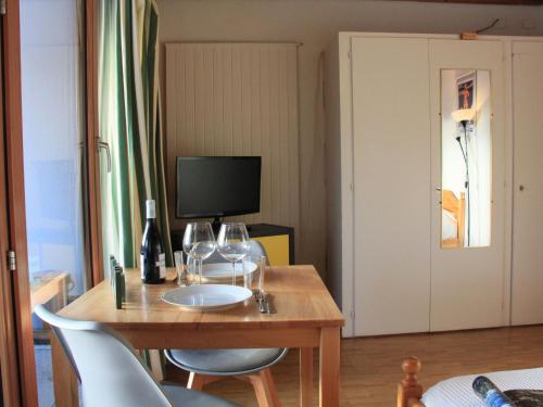pokój z drewnianym stołem i kieliszkami do wina w obiekcie Studio La Bercière 7 by Interhome w mieście Villars-sur-Ollon