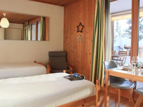 1 dormitorio con 2 camas, escritorio y mesa en Studio La Bercière 7 by Interhome, en Villars-sur-Ollon