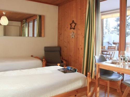 a bedroom with two beds and a desk and a table at Studio La Bercière 7 by Interhome in Villars-sur-Ollon