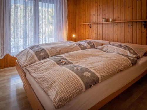 - 2 lits dans une chambre dotée de murs en bois dans l'établissement Apartment Jorasse A 1 by Interhome, à Ovronnaz