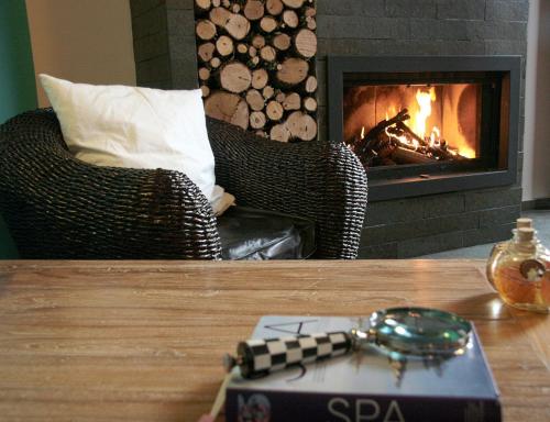 a remote control on a table in front of a fireplace at Eco Hotel Boutique & Spa Capitulo Trece - Adults Only in Maderuelo