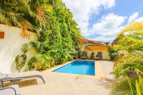 uma piscina em frente a um edifício com árvores em Vida Feliz Casitas em Sayulita