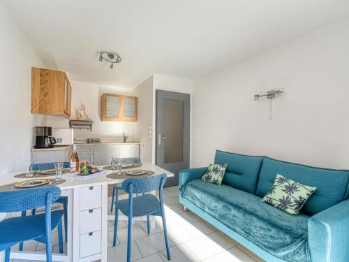 un salon avec un canapé bleu et une cuisine dans l'établissement Apartment Port d'Attache-9 by Interhome, à Fréjus