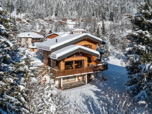a log home covered in snow in the woods at Chalet Banksia by Interhome in Ovronnaz