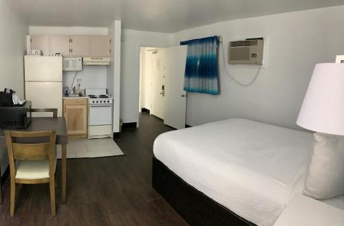 a bedroom with a bed and a table and a kitchen at Tropical Seas Hotel in Myrtle Beach