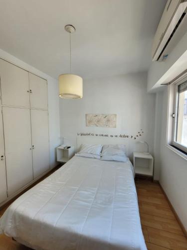um quarto branco com uma cama grande em Oasis Lodging em Buenos Aires