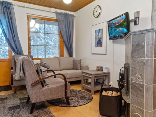 een woonkamer met een bank en een tv bij Holiday Home Alppitalo sinitähti 9 apt 1 by Interhome in Tahkovuori