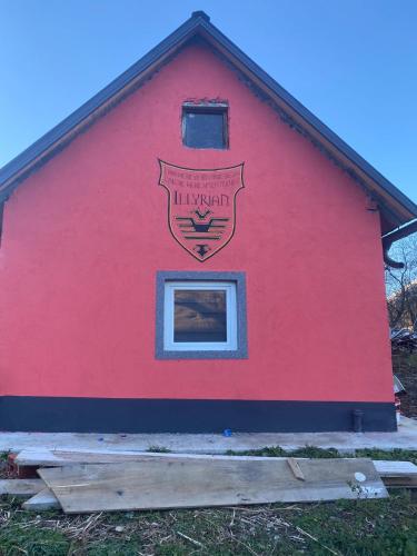 a red building with a sign on the side of it at Casa Illyria in Gusinje