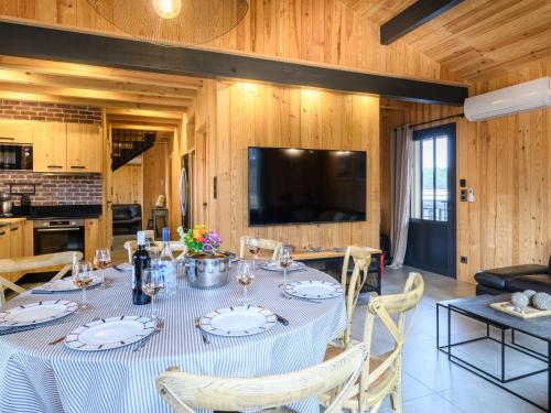 une salle à manger avec une table avec des chaises et une télévision dans l'établissement Holiday Home Palot 35 by Interhome, à Mimizan