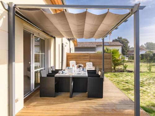 un patio avec une table et des chaises sur une terrasse dans l'établissement Holiday Home Lamanchs by Interhome, à Mimizan
