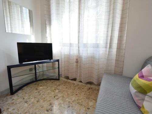 een woonkamer met een flatscreen-tv en een raam bij Studio Fra Cristoforo Studio Apartment by Interhome in Milaan
