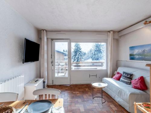a living room with a couch and a large window at Studio La Christaz-7 by Interhome in Saint-Gervais-les-Bains
