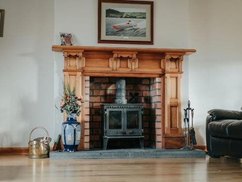 a living room with a fireplace with a picture above it at Holiday Home Ceilidhtail Cottage by Interhome in Drumnadrochit
