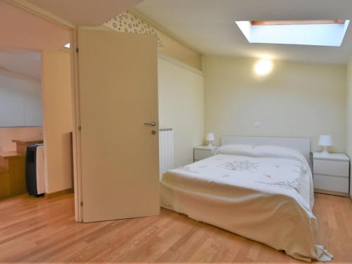 - une chambre avec un grand lit blanc et une lucarne dans l'établissement Apartment Duomo Mansarda by Interhome, à Iseo